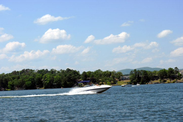 Lake Hamilton a lake in Hot Springs Arkansas with boat with wake and mountains and blue sky in the background