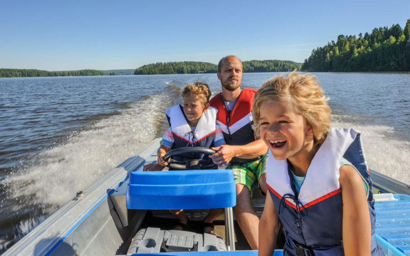 Family on a speed boat in a lake in arkansas that is insured by Farm Bureau Insurance.