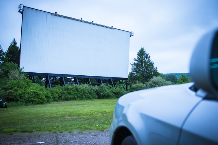 drive-in movie theater with one car waiting for the feature film to begin.