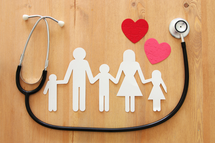 Health Insurance concept image of Stethoscope and family on wooden table.